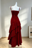 Red evening gown on a mannequin against a white wall.