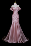 Pink evening gown on a mannequin against a black background