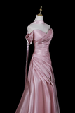 Pink evening gown on a mannequin against a black background