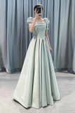 Woman wearing a light green evening gown with a plain background