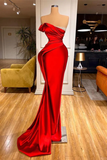 Red evening gown on a mannequin in a room with furniture and decor.