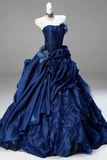 Navy blue gown with floral details on a mannequin against a gray background