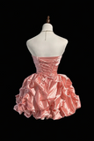 Pink strapless dress on a mannequin against a black background