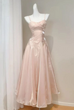 Pink evening gown on a mannequin against a white wall