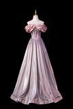 Pink evening gown on a mannequin against a black background