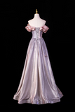 Elegant purple gown with floral details on a mannequin against a black background
