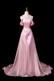 Pink evening gown on a mannequin against a black background
