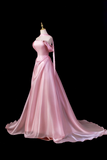 Pink evening gown on a mannequin against a black background