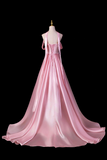 Pink evening gown on a mannequin against a black background