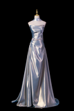 Silver evening gown on a mannequin against a black background