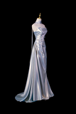 Silver evening gown on a mannequin against a black background