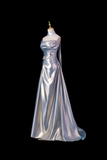 Silver evening gown on a mannequin against a black background