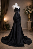 Black evening gown on a mannequin against a decorative background