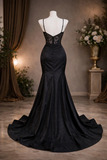 Black evening gown on a mannequin against a neutral background