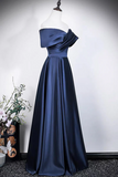 Navy blue evening gown on a mannequin against a white wall.