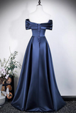 Navy blue evening gown on a mannequin against a plain background