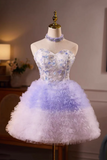 Short, strapless dress with a gradient of blue and white on a mannequin against a neutral background.