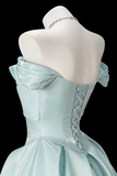 A light mint green off-the-shoulder corset ball gown displayed on a white mannequin against a solid black background.