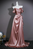 A floor-length off-the-shoulder satin gown in a dusty rose pink color, displayed on a white mannequin against a dark gray wall.
