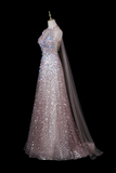 A floor-length formal gown displayed on a mannequin against a black background. The dress is heavily embellished with iridescent sequins and beads in a pale pink-lilac tone, with sheer long sleeves and a long matching veil draping from the neckline.