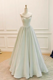 A floor-length A-line ball gown displayed on a mannequin in an indoor room. The dress has a strapless neckline with delicate silver beadwork and a flowing chiffon skirt in a very pale icy blue-green tone.