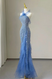 A light blue evening gown with silver sequins and layered tulle ruffles, displayed on a white mannequin in an indoor studio setting.