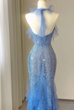 A light blue sequined evening gown displayed on a mannequin in an indoor room. The dress features a halter-style back with a sheer tulle bow, a fitted bodice covered in shimmering sequins, and a flared tulle hem.