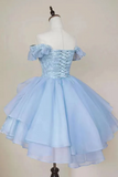 A light blue off-the-shoulder tulle dress displayed on a white mannequin torso against a plain beige background.
