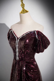 A burgundy sequined off-the-shoulder evening gown displayed on a cream mannequin torso with a gold neck cap, set against a neutral gray background.