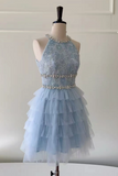A light blue sleeveless tulle dress displayed on a mannequin. The dress features a heavily embellished lace bodice with silver beadwork and crystal-like accents, a matching embellished waistband, and a layered ruffled tulle skirt.