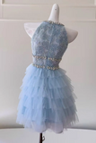 A light blue tulle dress displayed on a white mannequin torso, featuring a beaded lace bodice, embellished waistband, and layered ruffled tulle skirt.