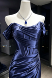 A dark blue satin off-the-shoulder evening gown displayed on a white mannequin torso, styled with a matching blue teardrop pendant necklace.