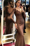 Woman in a brown evening gown with lace details taking a mirror selfie.