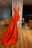 Orange evening gown on a mannequin in a room with furniture and decor.