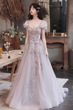 A woman wearing a formal A-line gown with puff sleeves, a sweetheart neckline, and intricate floral lace applique, standing in a rustic indoor setting with a table and fireplace in the background.